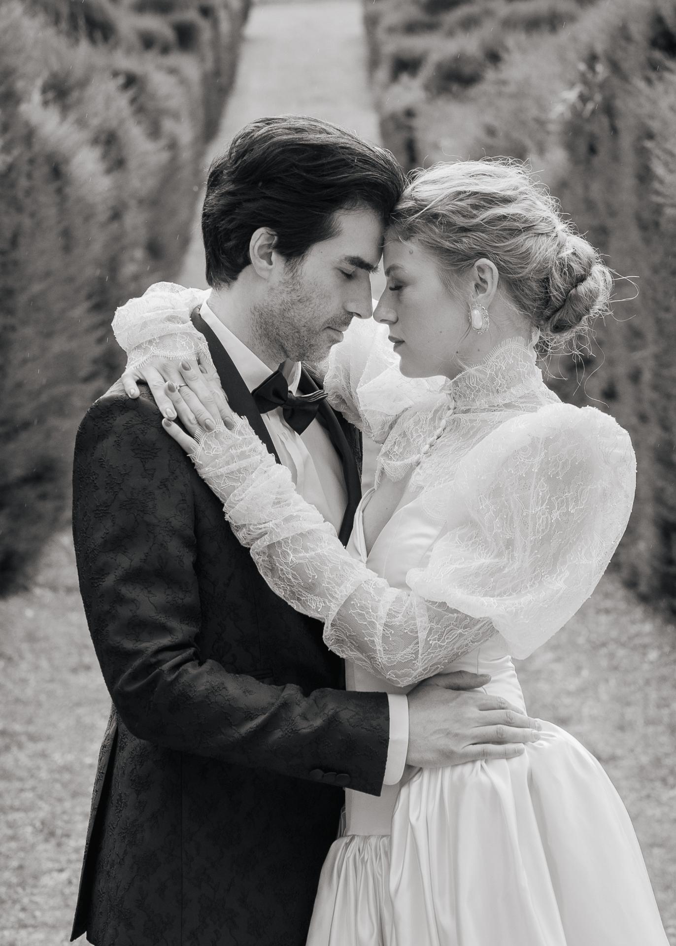 Intimate black and white portrait of a bride and groom embracing during a luxury wedding at Castello di Celsa, Tuscany.
