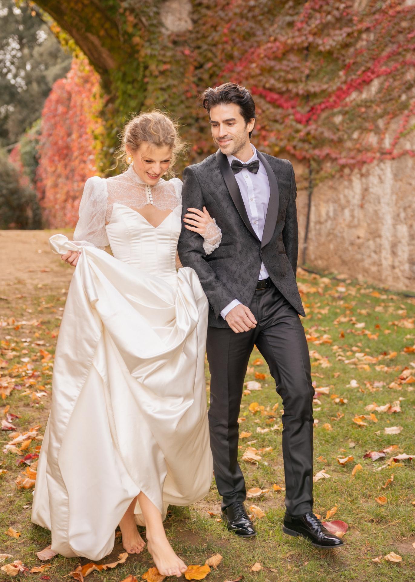 Bride and groom walking together during an autumn wedding at Castello di Celsa in Tuscany.