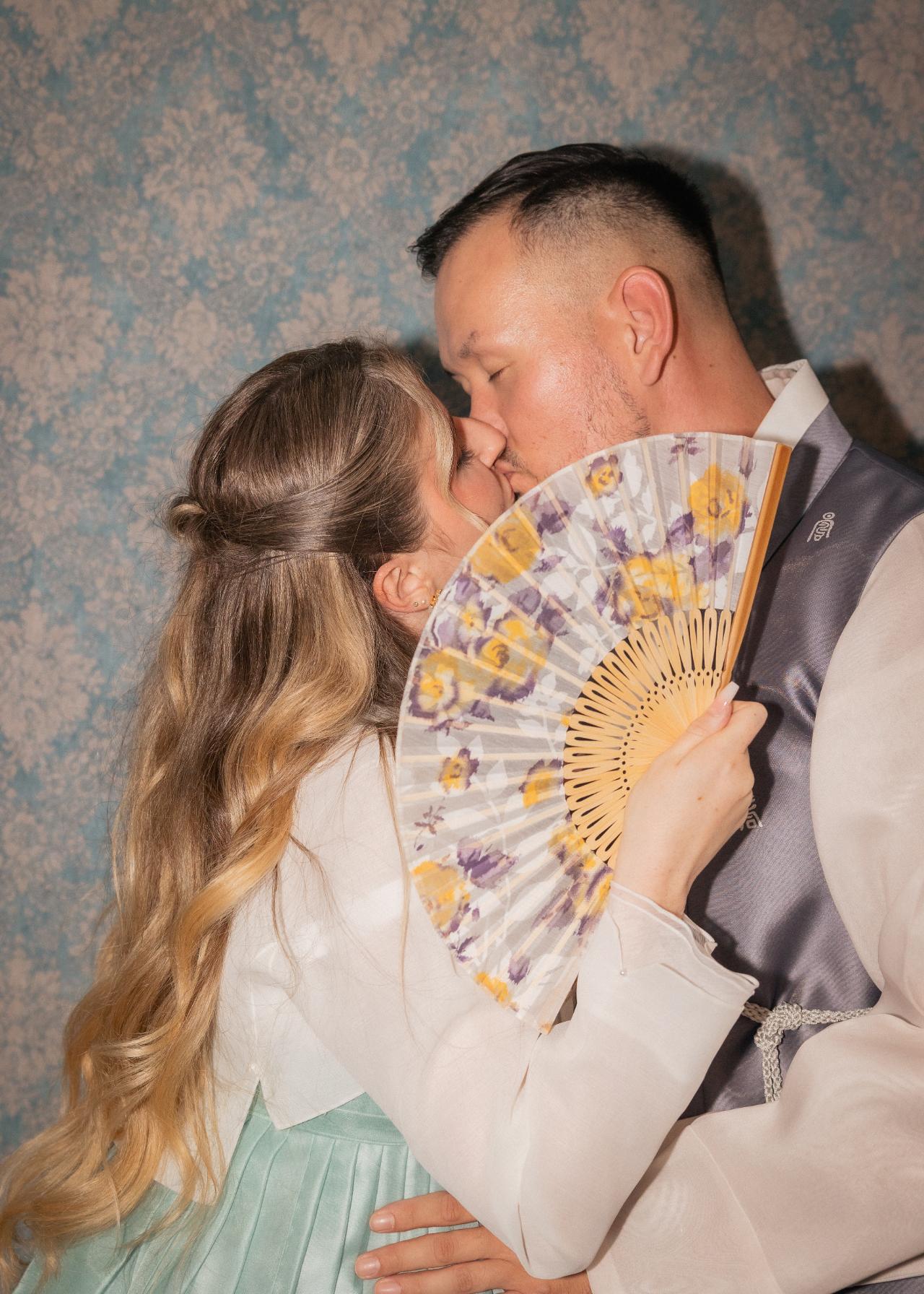 Interkulturelle Hochzeit mit kulturellen Outfits des Brautpaares