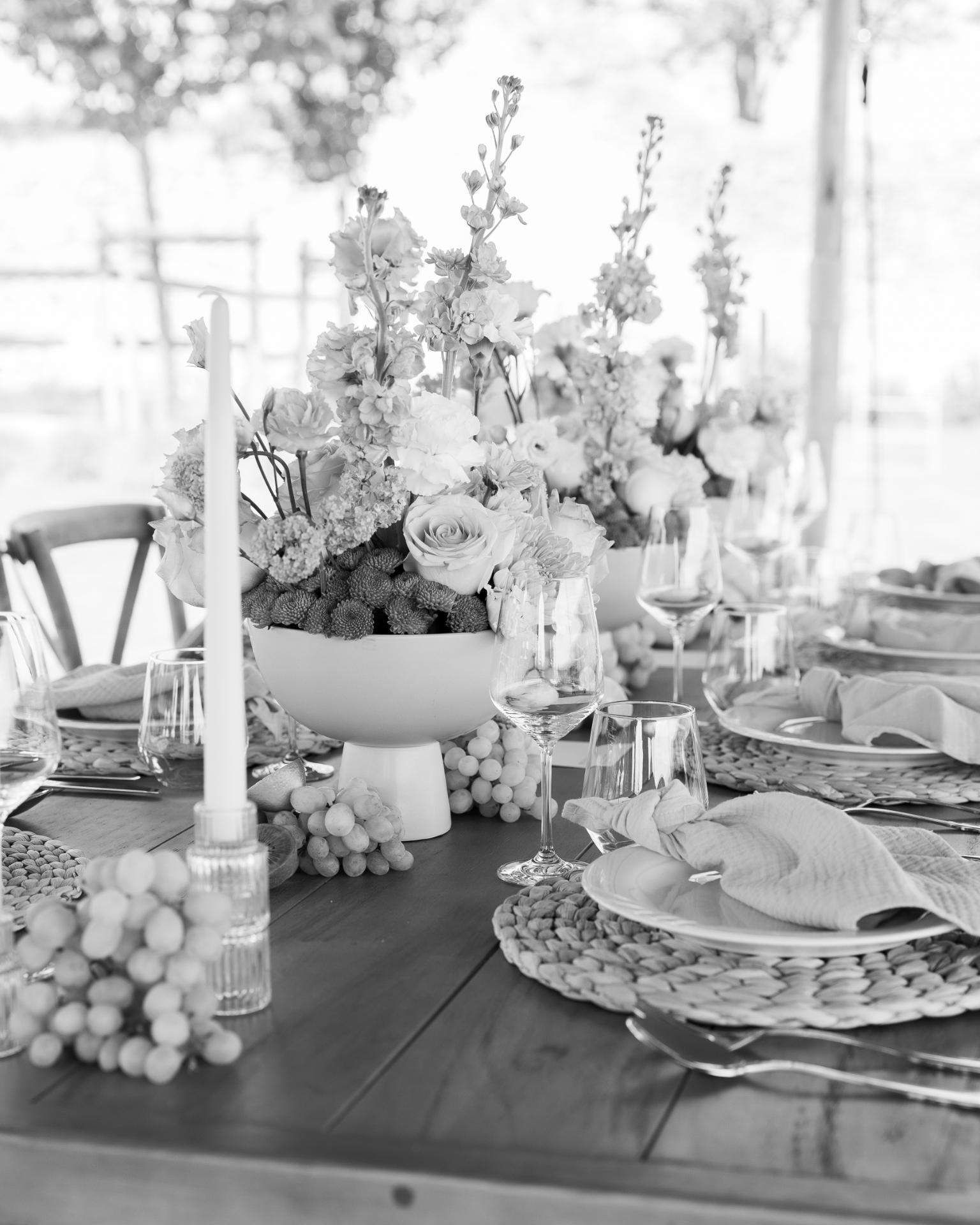 Elegant wedding table setting with floral centerpiece, candles and fine tableware