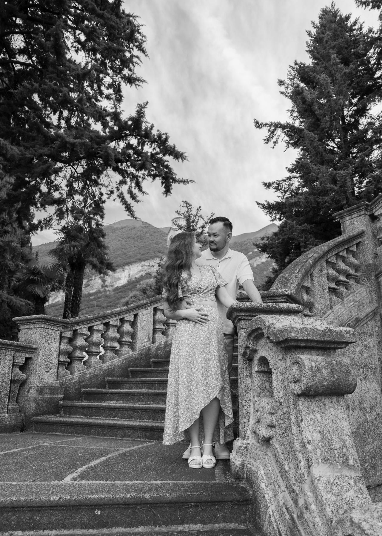 Engaged couple standing on a stone staircase at a Lake Como villa