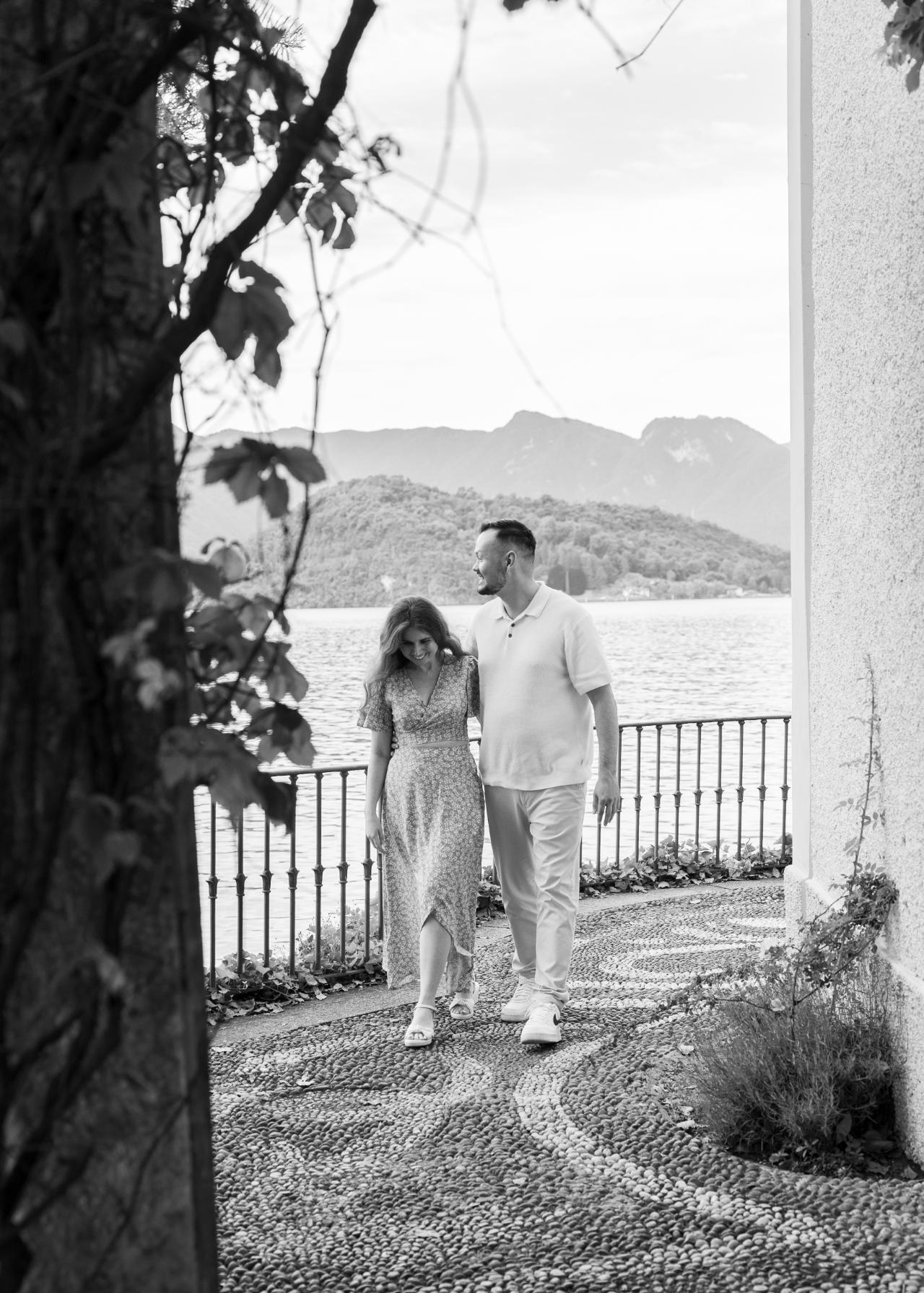 Engaged couple walking together on a villa terrace by Lake Como