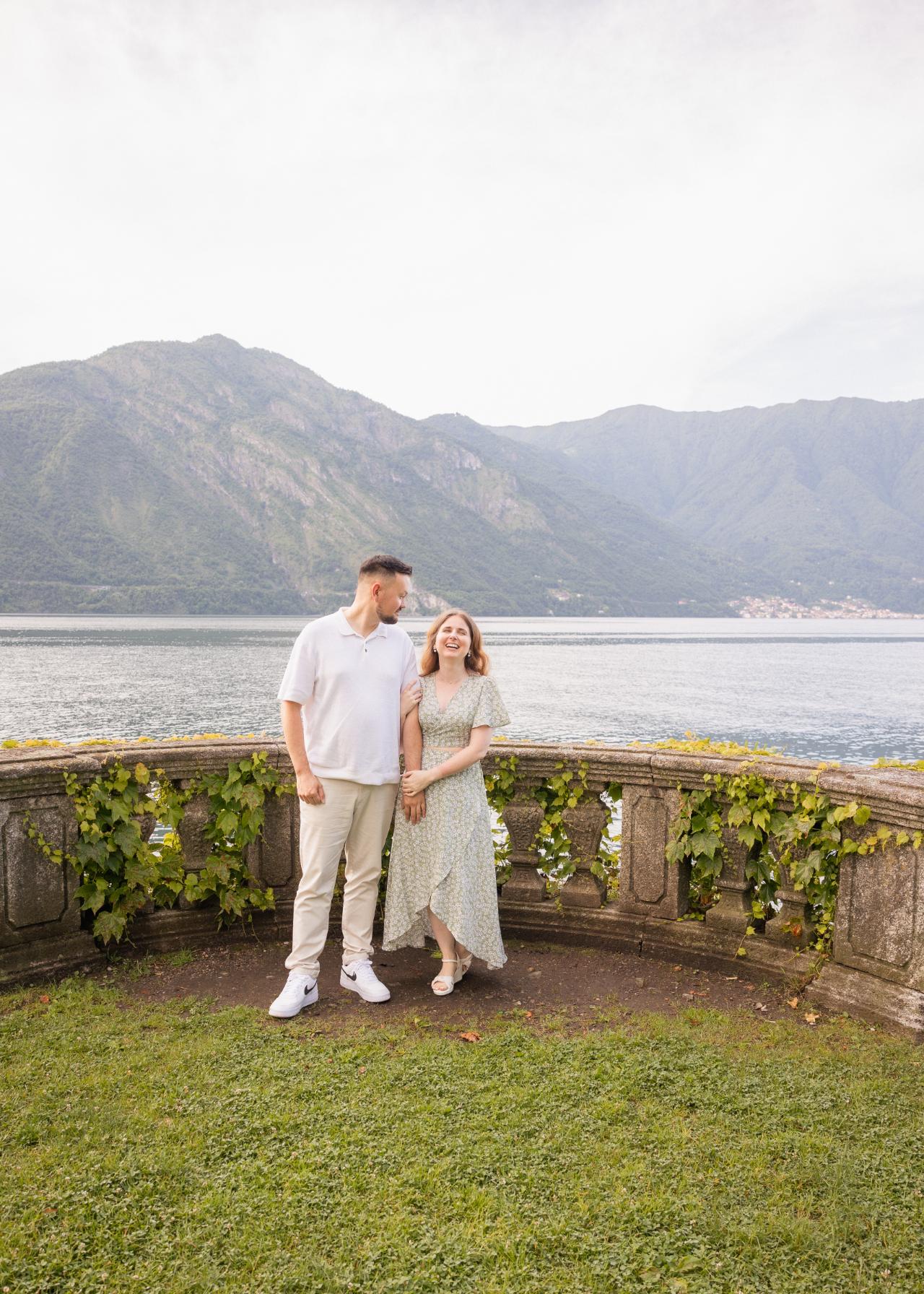 Engaged couple standing in a villa garden by Lake Como