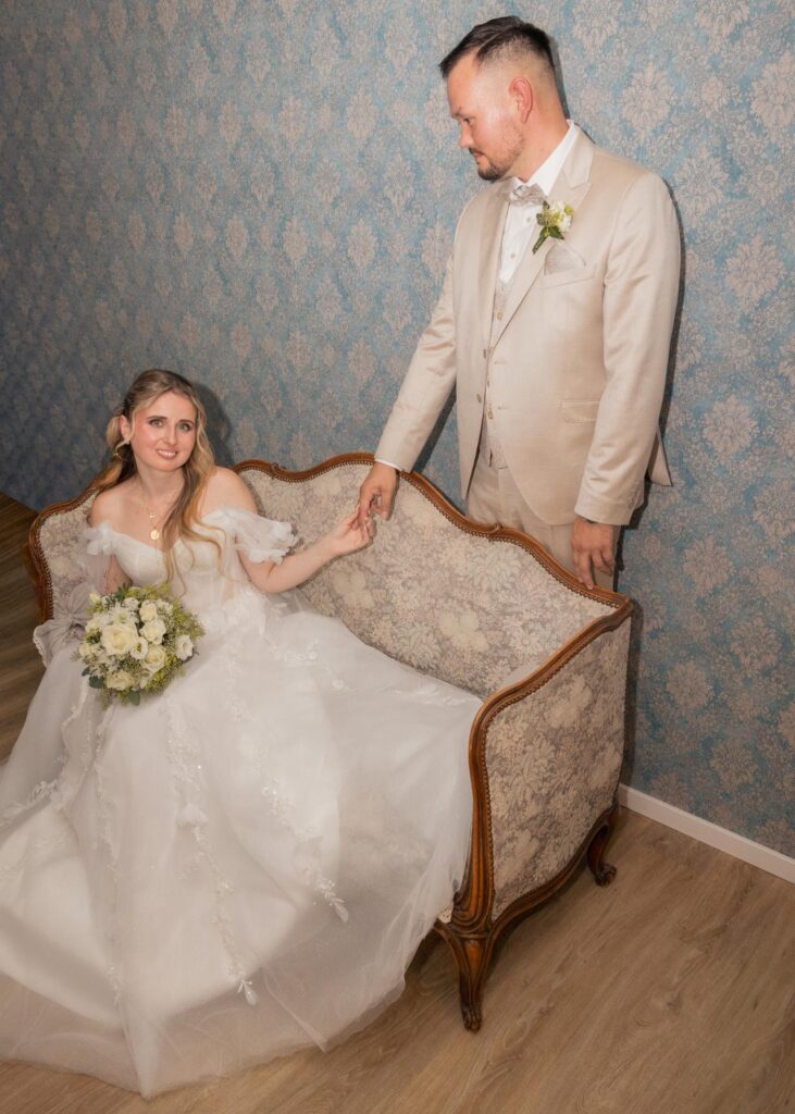 Bride and groom holding hands during an elegant indoor wedding portrait