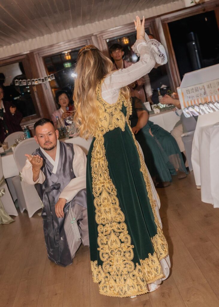 Bride and groom performing a traditional cultural wedding dance during the reception, surrounded by guests
