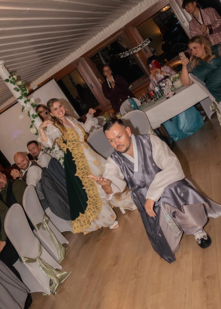 Bride and groom performing a traditional cultural wedding dance during the evening reception, surrounded by guests