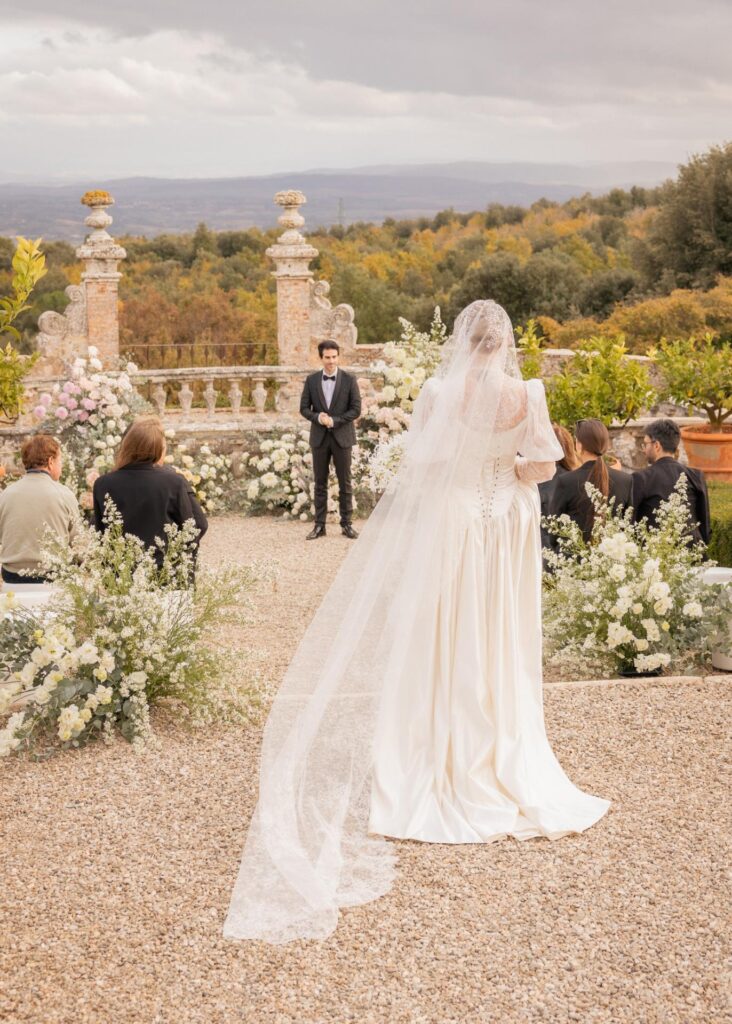 Bride walking down the aisle during an outdoor wedding ceremony at Castello di Celsa in Tuscany