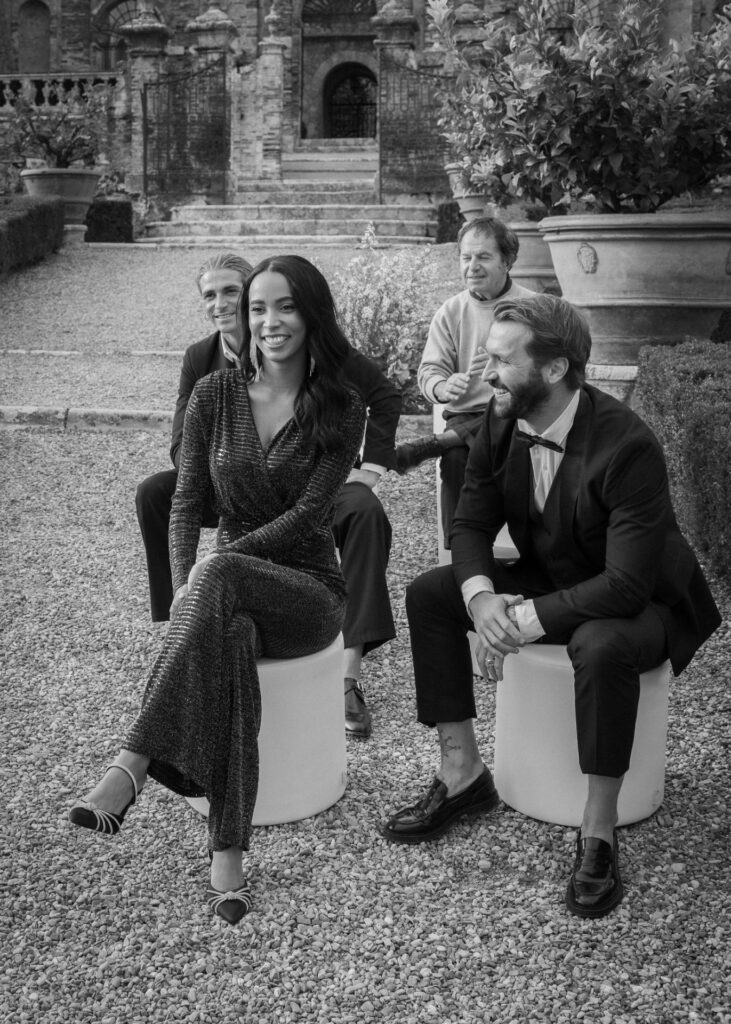 Wedding guests laughing during an intimate celebration at Castello di Celsa in Tuscany, captured in black and white