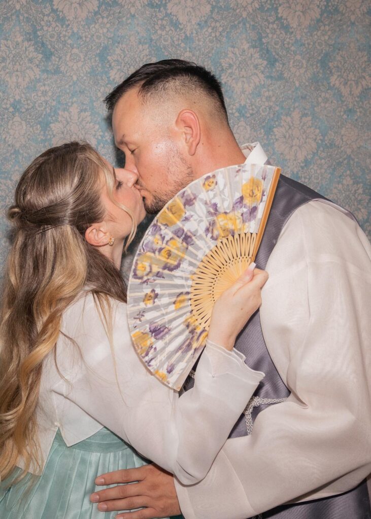 Bride and groom sharing a kiss during a vintage-inspired wedding portrait