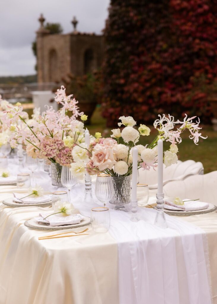 Elegant wedding table setting with pastel florals, candles, and fine glassware at an Italian villa outdoor reception.
