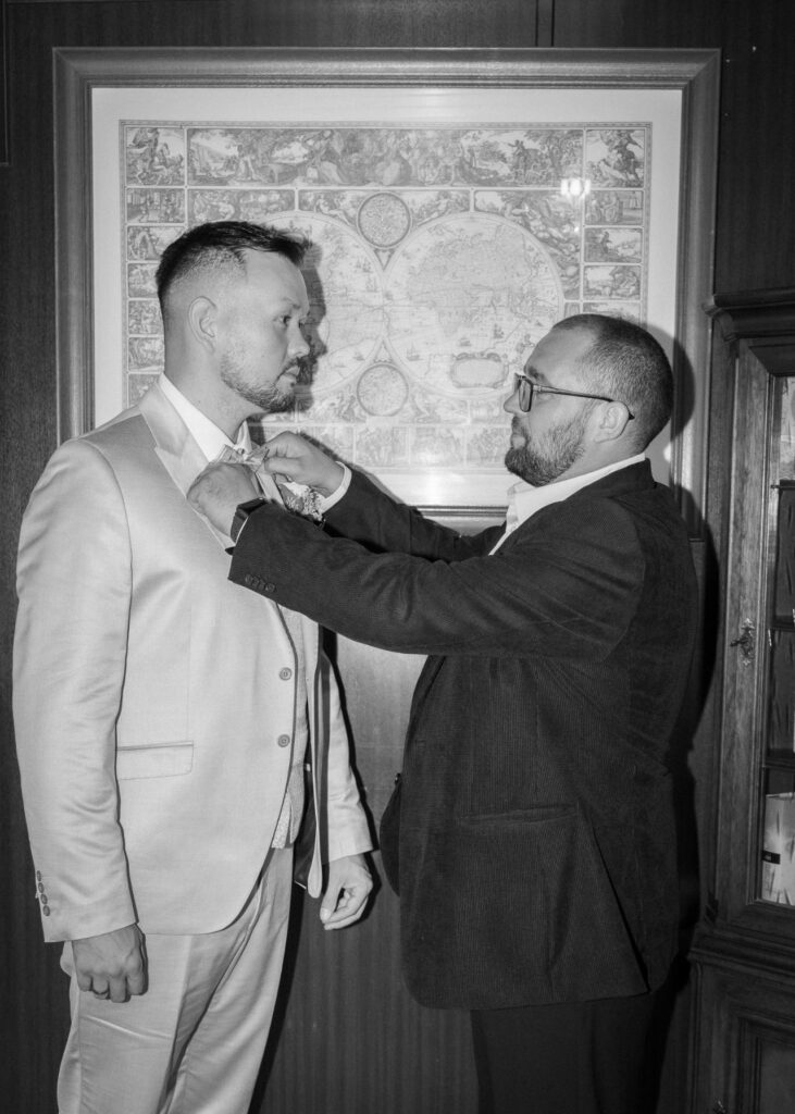Best man helping the groom adjust his bow tie before the ceremony