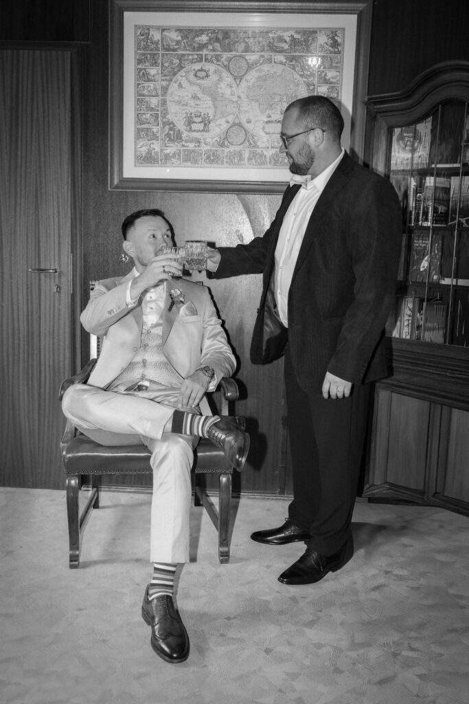 Groom sharing a toast with his best man before the wedding