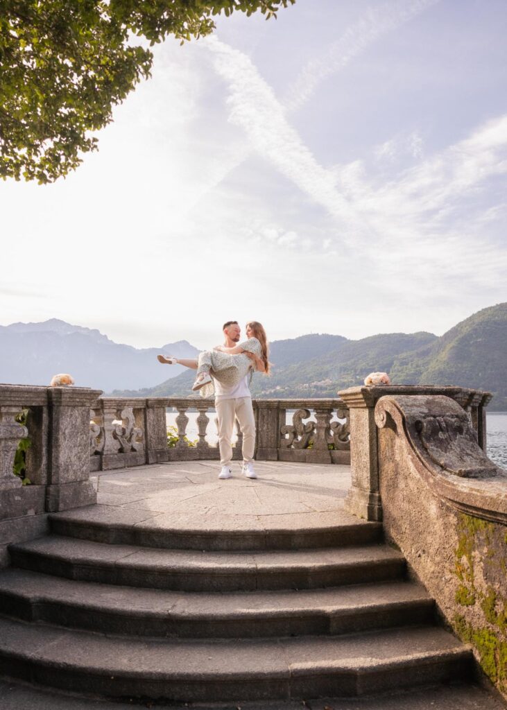 Couple embracing on a villa terrace overlooking Lake Como